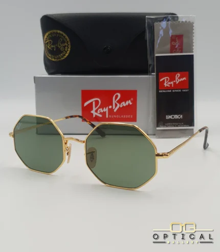 Lunettes de soleil octogonales Ray-Ban RB1972 avec monture fine en métal doré, verres verts et manchons écaillés, présentées avec leur étui noir - Optical Gallery.