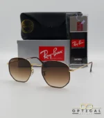 Lunettes de soleil Ray-Ban Hexagonal Flat Lenses RB3548N monture bicolore en métal doré et cerclage marron avec verres dégradés marrons, étui et boîte d'origine.