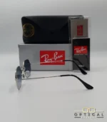 Lunettes de soleil Ray-Ban Octagonal RB3556 argentées avec verres dégradés gris, étui noir, boîte grise et accessoires.